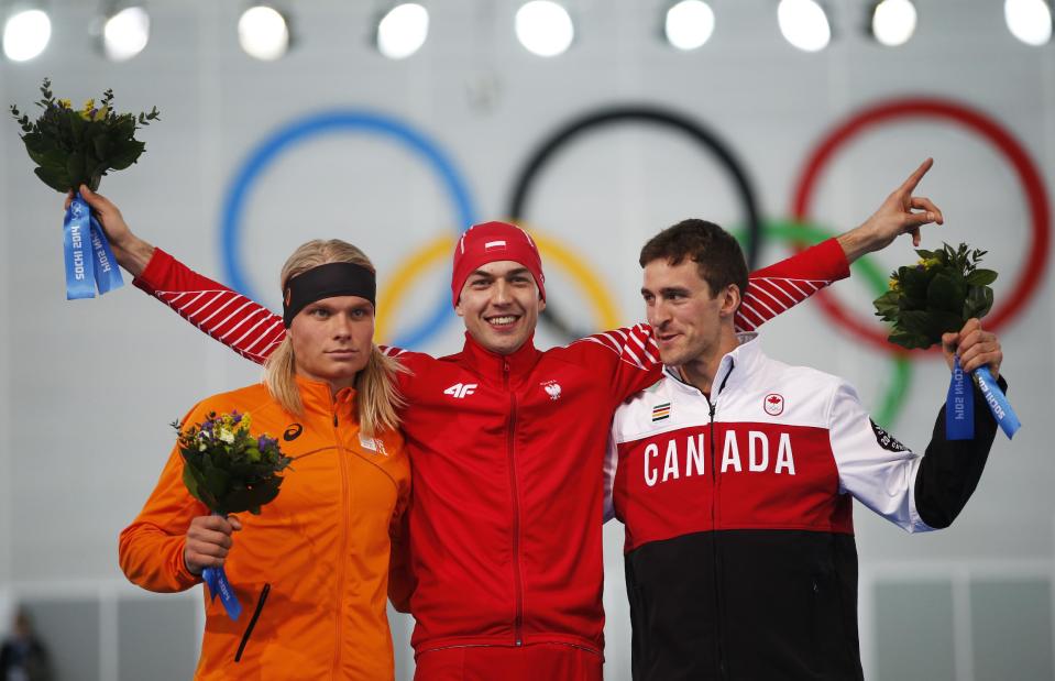 From left to right, silver medallist Koen Verweij of the Netherlands, gold medallist Poland's Zbigniew Brodka and bronze medallist Canada's Denny Morrison stand on the podium during the flower ceremony for the men's 1,500-meter speedskating race at the Adler Arena Skating Center during the 2014 Winter Olympics in Sochi, Russia, Saturday, Feb. 15, 2014. Verweij lost the gold medal by three thousandth of a second. (AP Photo/Pavel Golovkin)