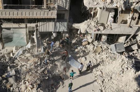 People dig in the rubble in an ongoing search for survivors at a site hit previously by an airstrike in the rebel-held Tariq al-Bab neighborhood of Aleppo, Syria, September 26, 2016. REUTERS/Abdalrhman Ismail