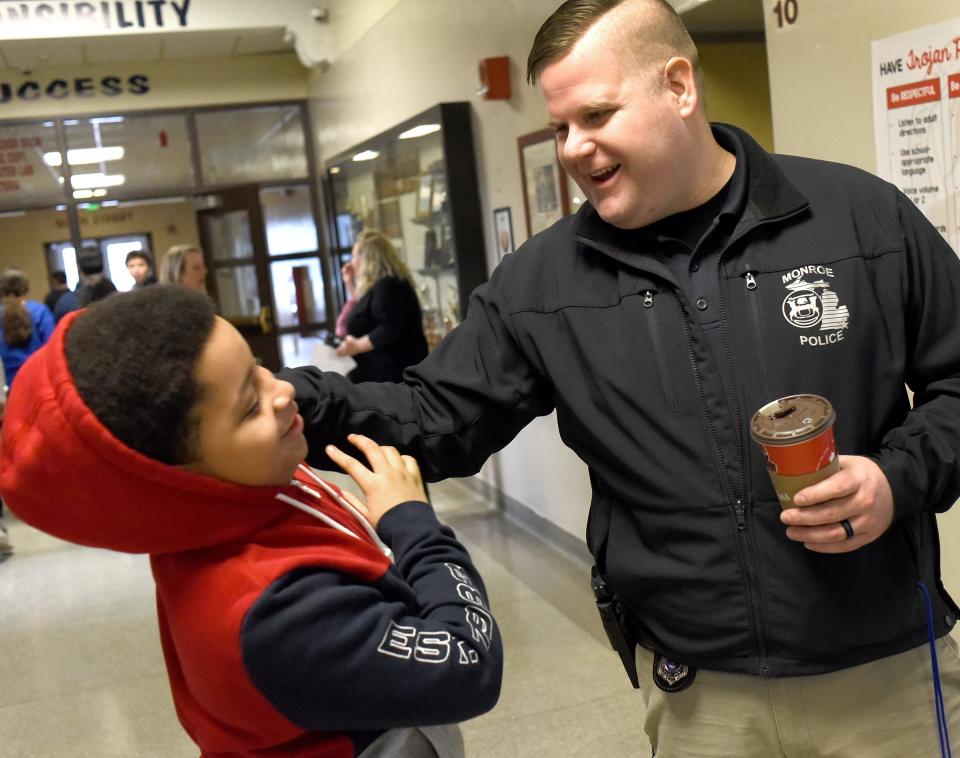 In this February, 2020 file photo, Monroe Middle School seventh grader Meeth McCray congratulates Student Resource Officer Brian (Winnie) Winsjansen after a special surprise presentation to recognize Winsjansen for being selected as the City of Monroe Police Officer of the Year.