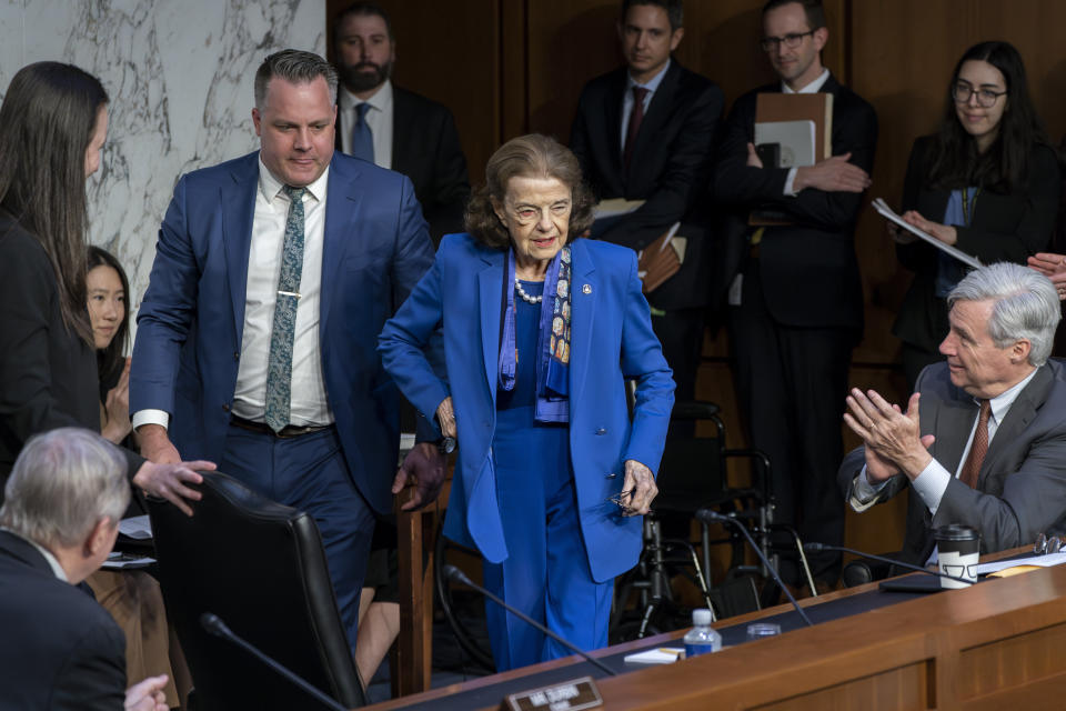 FILE - Sen. Dianne Feinstein, D-Calif., is welcomed back to the Senate Judiciary Committee by Sen. Sheldon Whitehouse, D-R.I., right, and others following a more than two-month absence, at the Capitol in Washington, May 11, 2023. (AP Photo/J. Scott Applewhite, File)