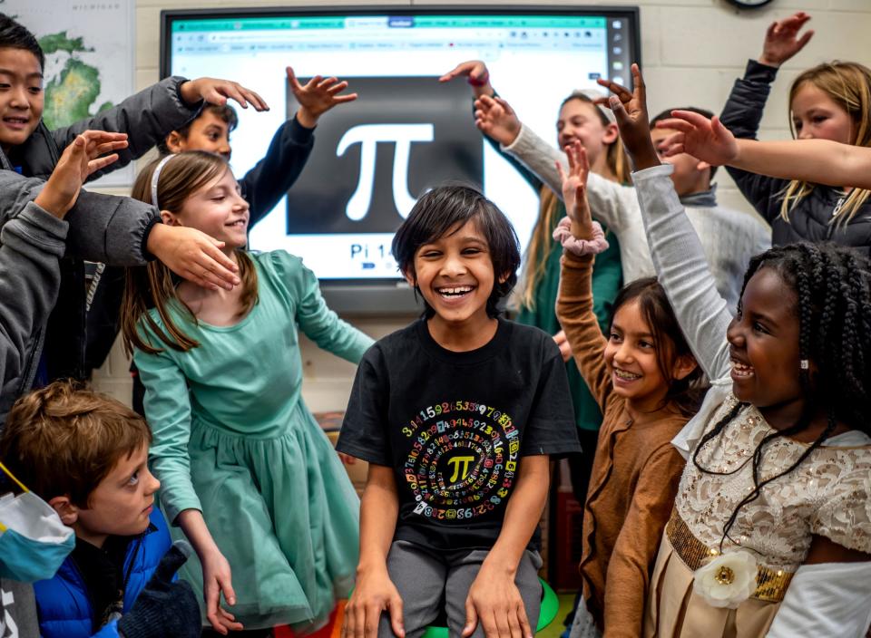 Emerson School third grader Keshav Hebsur, center, 8, sits among his classmates that are part of Team Keshav in their classroom at the school in Ann Arbor on March 2, 2023. Keshav has nearly 1,300 pi digits memorized and won't stop until he reaches 100,000 digits.