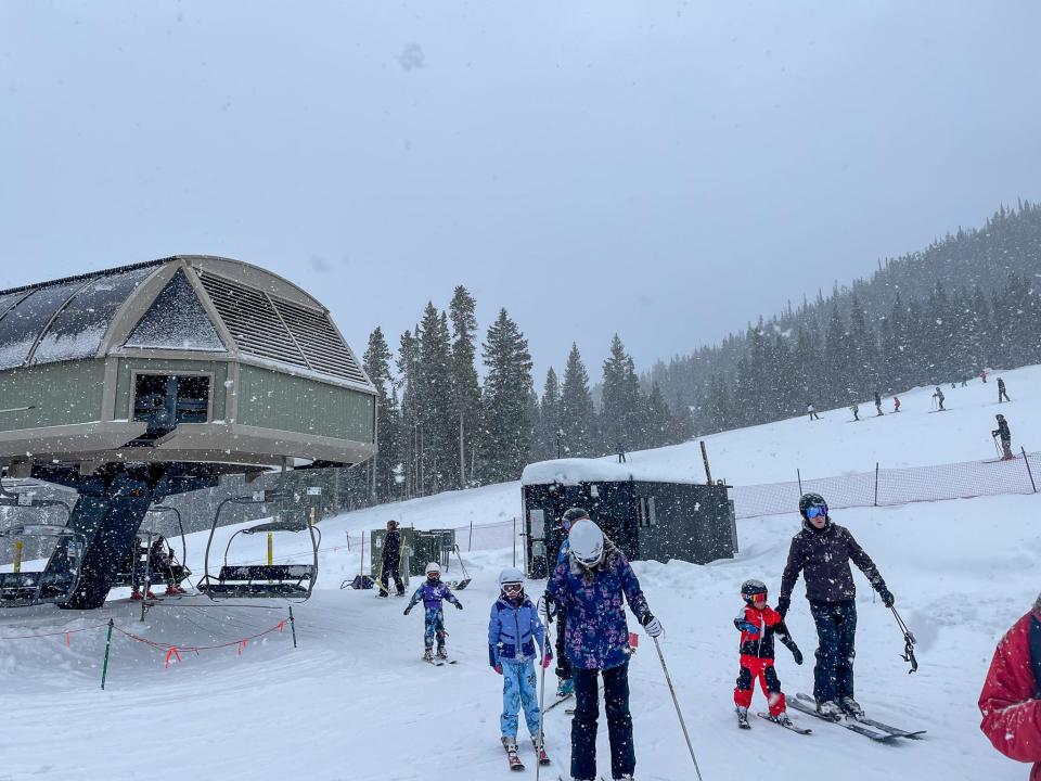 A family of skiers gets off a lift.