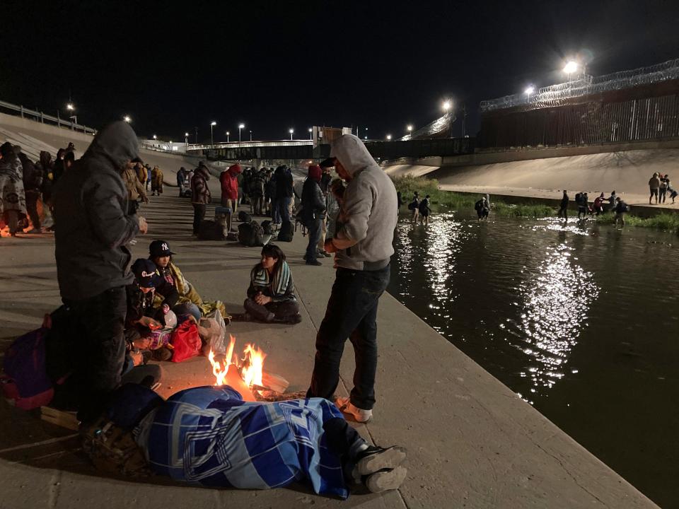 December 20, 2022: Migrants congregate at campfires on the banks of the Rio Grande in Ciudad Juárez, Mexico, as others wade through shallow waters toward the United States and its border wall. Restrictions that prevented many from seeking asylum in the U.S. remained beyond their anticipated end.
