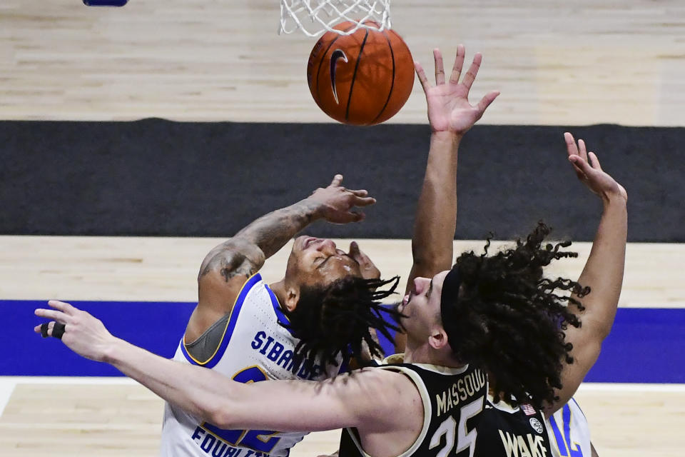 Pittsburgh forward Nike Sibande battles for a rebound with Wake Forest forward Ismael Massoud during the first half of an NCAA college basketball game, Tuesday, March 2, 2021, in Pittsburgh. (AP Photo/Fred Vuich)