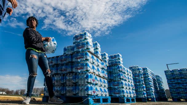 PHOTO: Volunteers load cases of water into vehicles in Flint, Mich., April 22, 2020. (Jake May/The Flint Journal via AP, FILE)