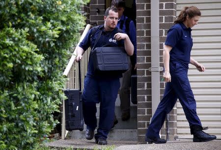 Federal police officers carry equipment as they exit a house after arresting a man during early morning raids in western Sydney, Australia, October 7, 2015. REUTERS/David Gray