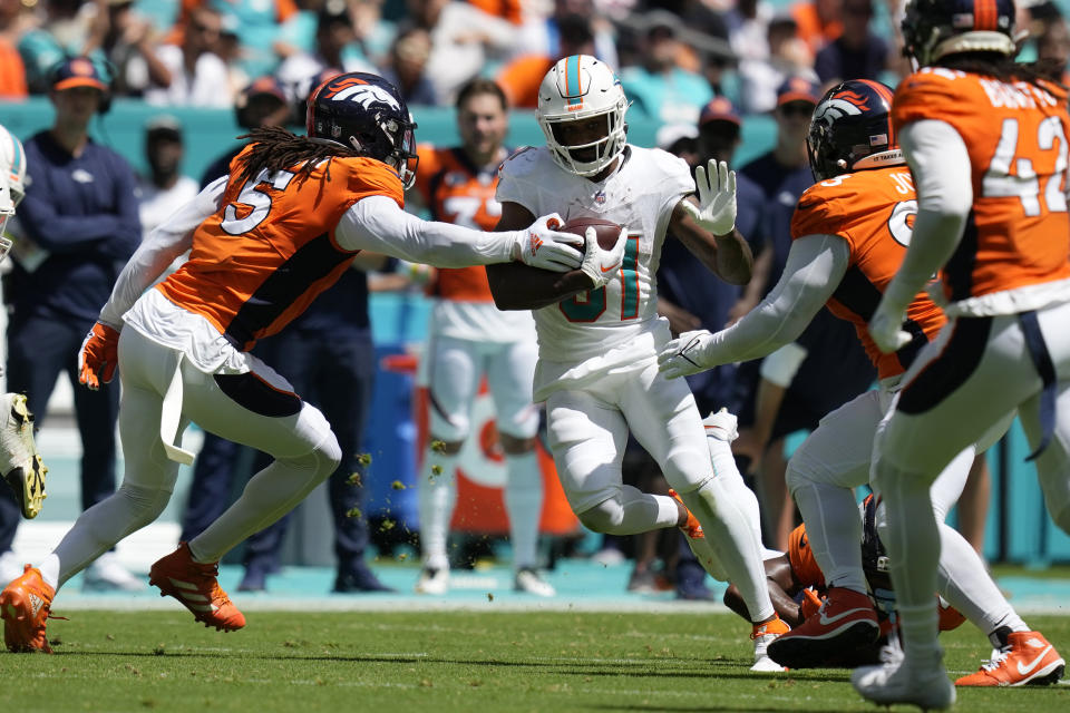 Denver Broncos linebacker Randy Gregory (5) attempts to stop Miami Dolphins running back Raheem Mostert (31) during the first half of an NFL football game, Sunday, Sept. 24, 2023, in Miami Gardens, Fla. (AP Photo/Rebecca Blackwell)