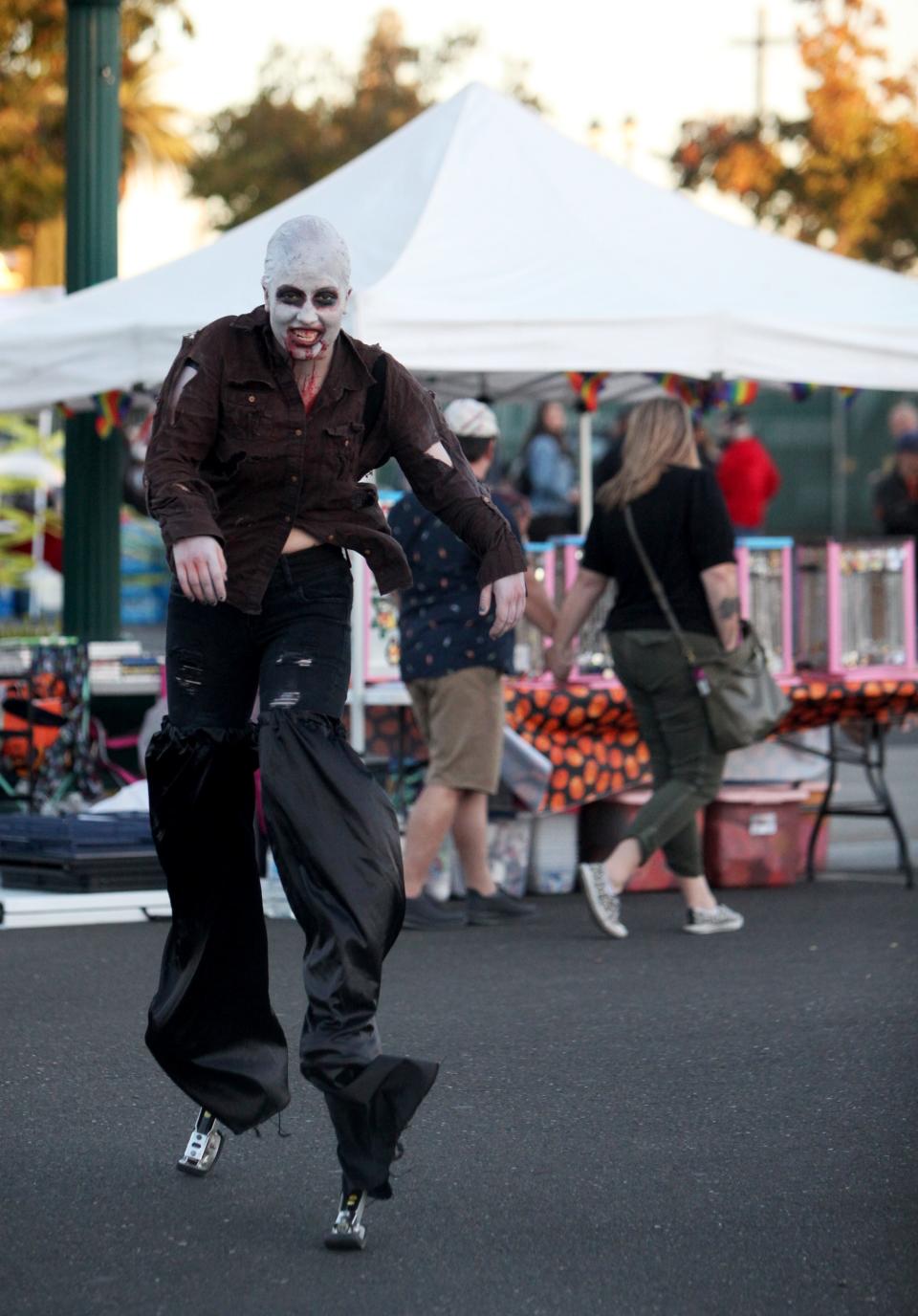 Zombie Tonya, of Sacramento,  walks on kangaroo stilts at the Lodi Zombie Walk at IDOL Beer Works, on Sunday, Oct. 23, 2022.