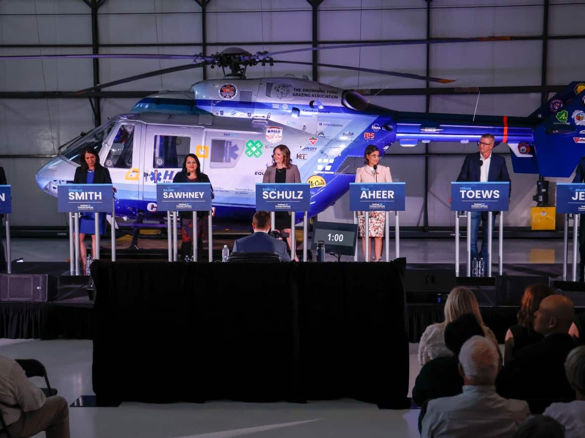 Candidates, left to right, Todd Loewen, Danielle Smith, Rajan Sawhney, Rebecca Schulz, Leela Aheer, Travis Toews, and Brian Jean, attend the United Conservative Party of Alberta leadership candidate's debate in Medicine Hat, Alta., Wednesday, July 27, 2022. (Jeff McIntosh/The Canadian Press - image credit)