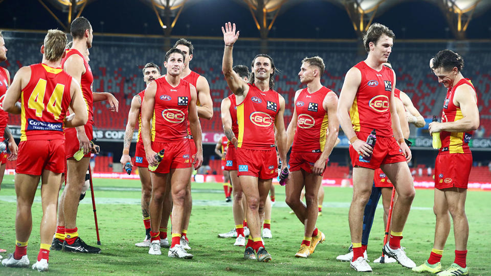 Seen here, Gold Coast Suns players walk off after their round two win in the AFL.