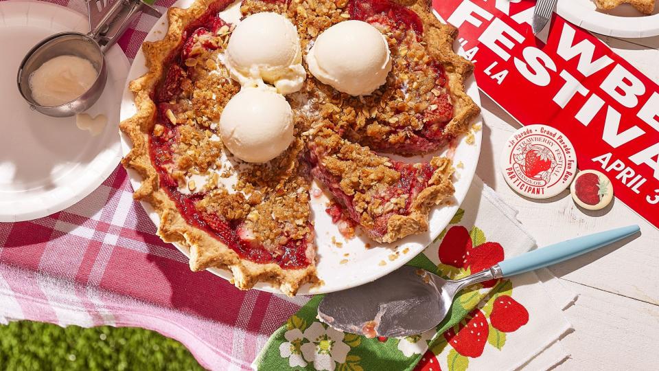 strawberry almond crumble pie on a table outside with scoops of ice cream on top