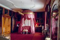 <p>This richly red damask bedroom boasts a circular canopy bed that is a luxurious and elegant example of the Rococo style—along with the rest of the castle. This 18th-century Danish castle also boasts one of the largest private collections of paintings in Denmark. </p>