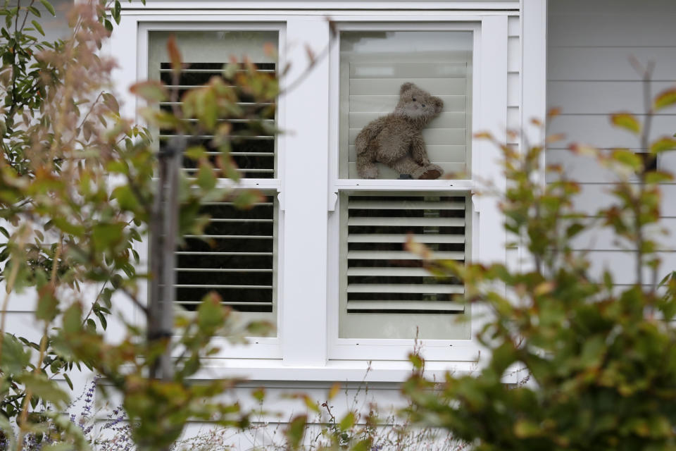 In this Sunday, March 29, 2020, photo, a teddy bear sits in the window of a house in Christchurch, New Zealand.New Zealanders are embracing an international movement in which people are placing teddy bears in their windows during coronavirus lockdowns to brighten the mood and give children a game to play by spotting the bears in their neighborhoods. (AP Photo/Mark Baker)