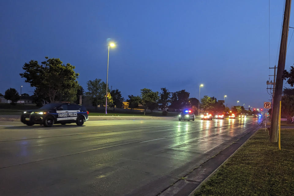 A police procession carries fallen Fargo Police Officer Jake Wallin's cremains to his funeral service in Pequot Lakes, Minn., on Saturday, July 22, 2023. Wallin was killed July 14 when a man armed with 1,800 rounds of ammunition, multiple guns and explosives began firing on officers who were responding to a traffic crash.(Ryan Janke/KFGO via AP)