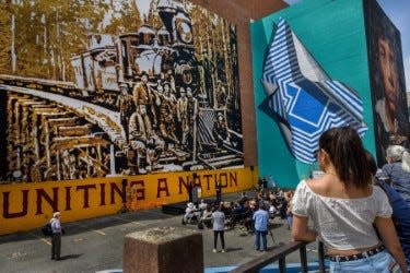 Muralist Maren Conrad unveils her mural to celebrate the 150th anniversary of the Transcontinental Railroad and honor Chinese immigrants outside the historic Elks Tower building in downtown Sacramento on May 13, 2019.