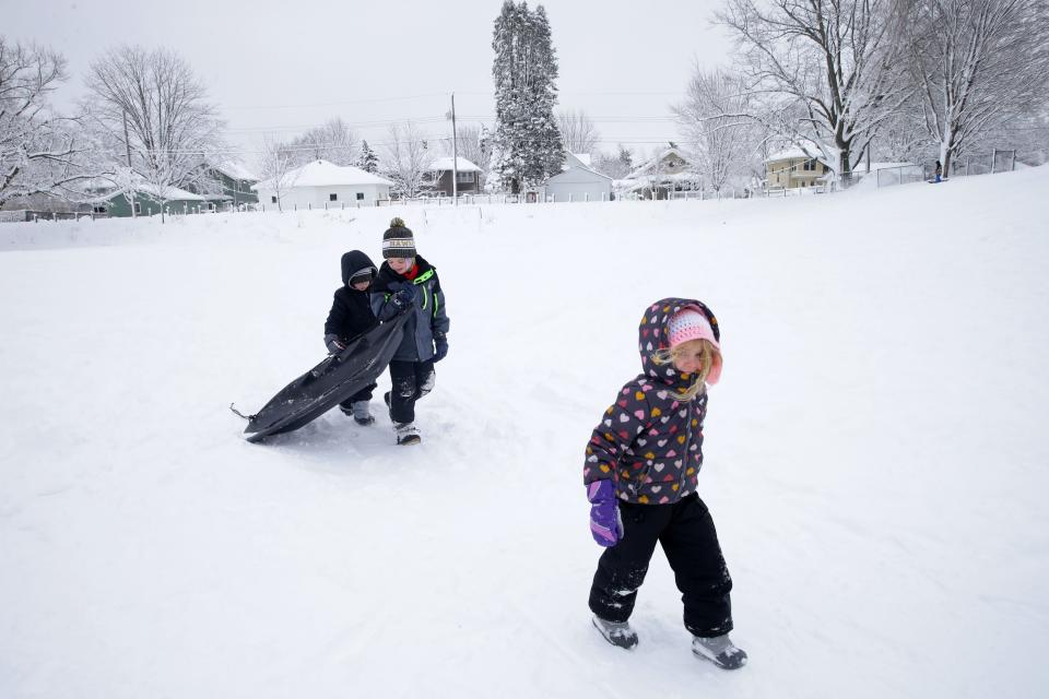 From left, Brooks Evans, 5, Leo Belk, 8, and Noel Belk, 4, walk back up a hill after sledding Wednesday, Jan. 10, 2024 at Longfellow Elementary School in Iowa City, Iowa.