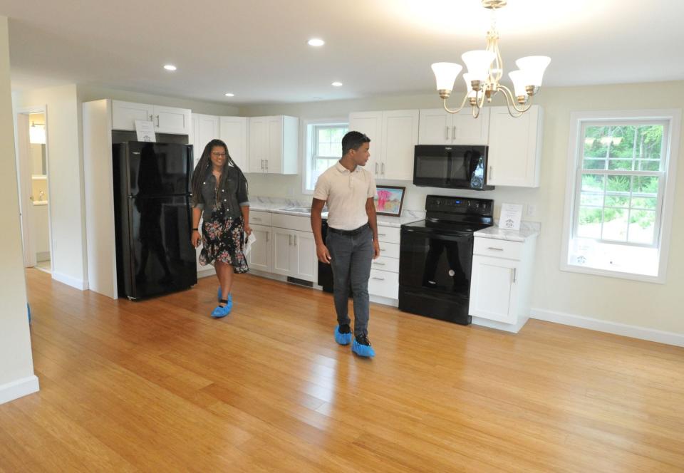 Jasmine Owens, left, and her son, Andre Owens-Butler, 18, right, check out the kitchen of their new Habitat for Humanity home in Hingham, Sunday, Aug. 27, 2023.
