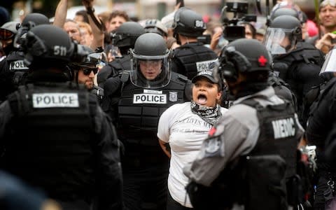 Police officers detain a protester against right-wing demonstrators following an "End Domestic Terrorism" rally in Portland - Credit: AP