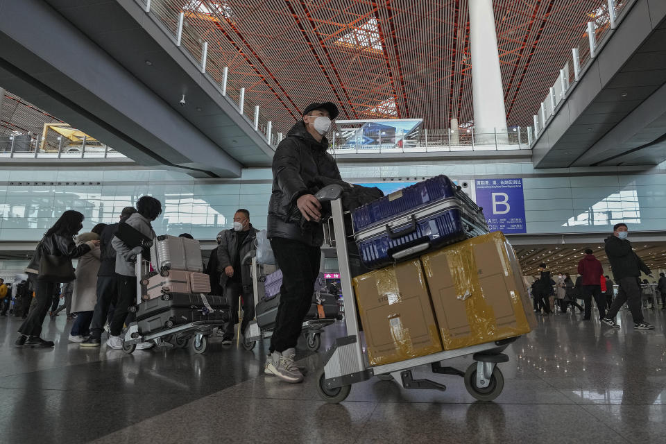 Passengers from Hong Kong arrive at Terminal 3 international arrival hall of the Beijing Capital International Airport in Beijing, Sunday, Jan. 8, 2023. Travelers crossing between Hong Kong and mainland China, however, are still required to show a negative COVID-19 test taken within the last 48 hours, a measure China has protested when imposed by other countries. (AP Photo/Andy Wong)