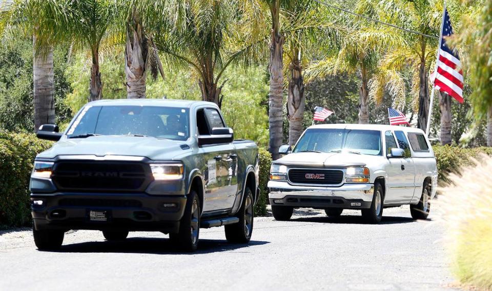 Vehicles drive past the San Luis Obispo home of Ellen Pezo on July 2, 2022, during a birthday celebration for her mother, U.S. Marine Corps veteran Elizabeth Ross hosted by Welcome Home Military Heroes. Ross turns 100 on July 4.