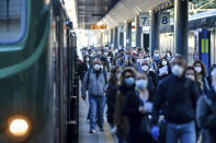 Commuters crowd Cadorna train station in Milan, Italy, Monday, May 4, 2020. Italy began stirring again Monday after a two-month coronavirus shutdown, with 4.4 million Italians able to return to work and restrictions on movement eased in the first European country to lock down in a bid to stem COVID-19 infections. (Claudio Furlan/LaPresse via AP)