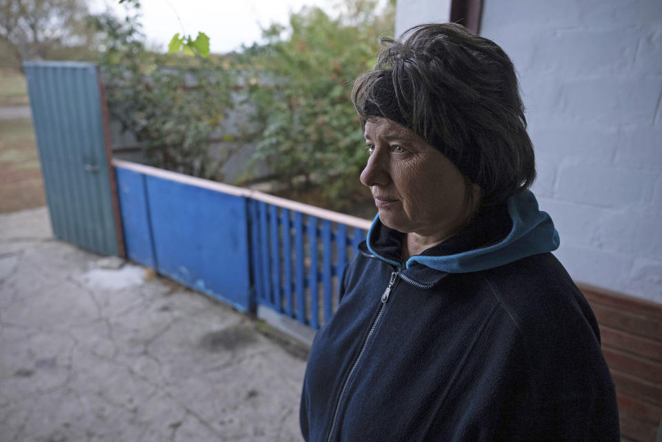 Liubov Kozyr, who lost her daughter and son-in-law in the attack, along with their son-in-law's parents, stands in front of her house in the village of Hroza near Kharkiv, Ukraine, Friday, Oct. 6, 2023. Ukrainian officials say at least 51 civilians were killed as the Russian rocket hit a village store and cafe in one of the deadliest attacks in recent months. (AP Photo/Alex Babenko)