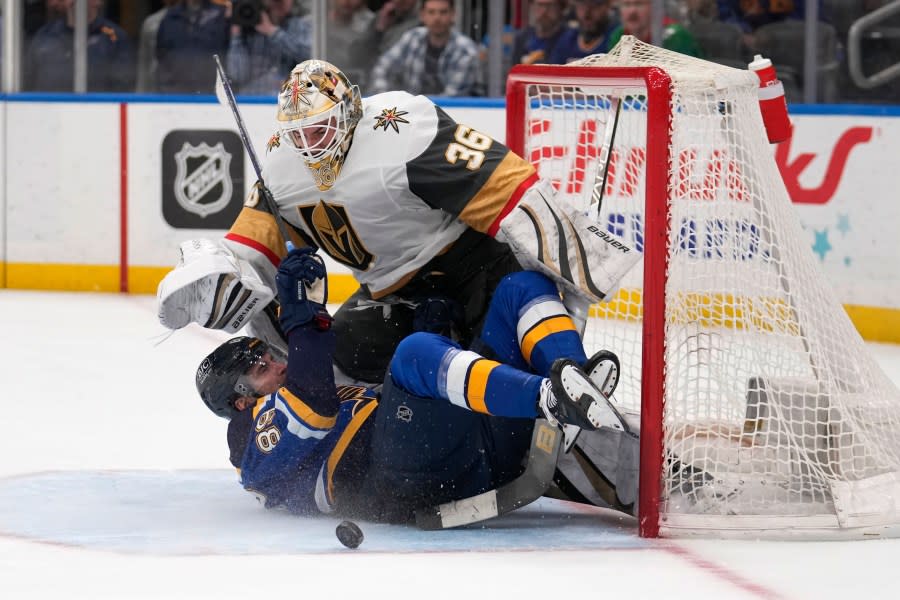 St. Louis Blues’ Pavel Buchnevich (89) slides into Vegas Golden Knights goaltender Logan Thompson (36) during overtime of an NHL hockey game Monday, March 25, 2024, in St. Louis. (AP Photo/Jeff Roberson)