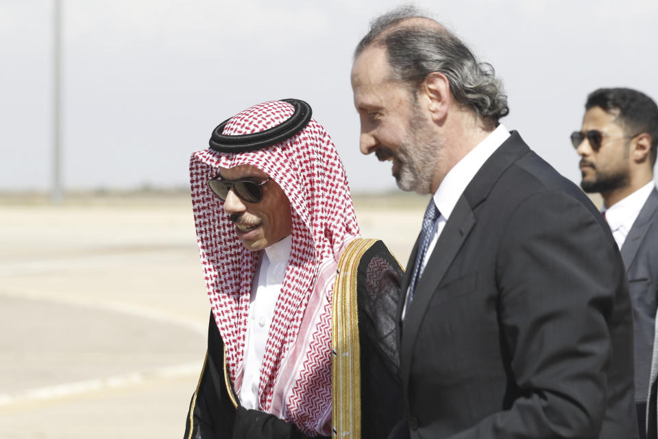 Saudi Minster of Foreign Affairs Faisal bin Farhan is escorted by the Syrian Minister of Presidential Affairs Mansour Azzam upon his arrival at Damascus airport Tuesday, April 18, 2023. (AP Photo/Omar Sanadiki)