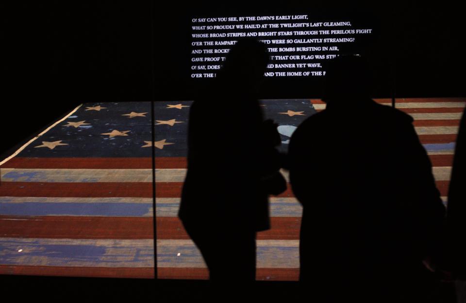 FILE - In this Nov. 21, 2008 file photo, people look at the original Star Spangled Banner, the flag that inspired the national anthem, inside a protective chamber at the National Museum of American History in Washington. The anthem was written after the flag was raised at Fort McHenry in Baltimore during the War of 1812, and events marking the bicentennial of the war are taking place around the country. (AP Photo/Jacquelyn Martin, File)