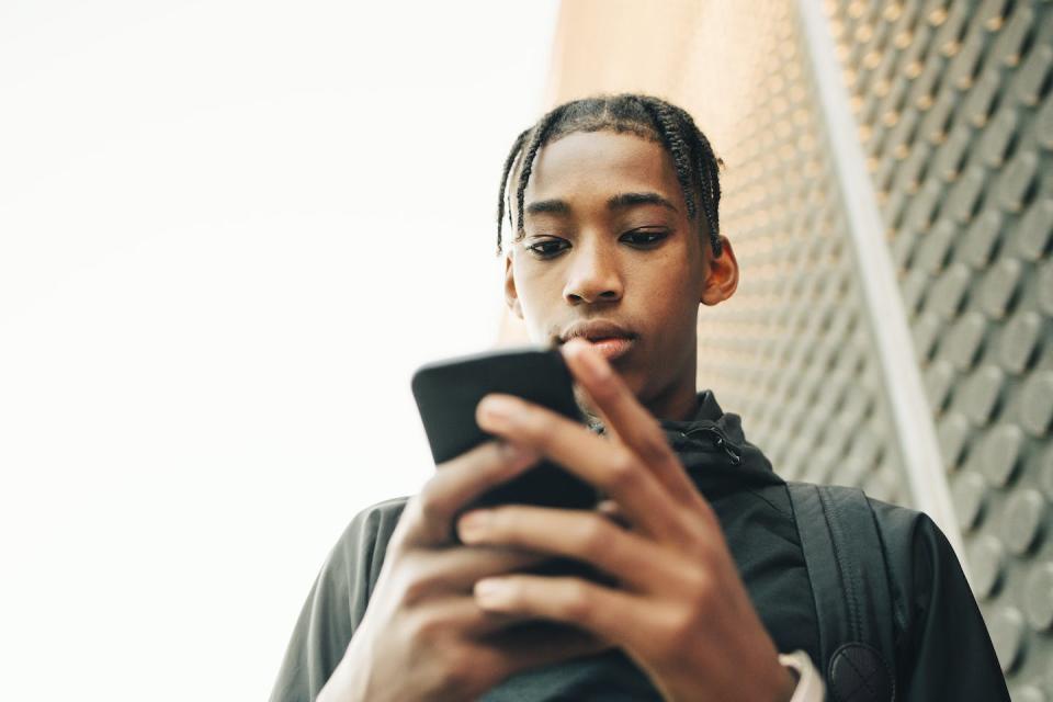 Black teens often seek video content about relationships. <a href="https://www.gettyimages.com/detail/photo/low-angle-view-of-serious-teenage-boy-using-mobile-royalty-free-image/1136196122" rel="nofollow noopener" target="_blank" data-ylk="slk:Maskot via Getty Images;elm:context_link;itc:0;sec:content-canvas" class="link ">Maskot via Getty Images</a>