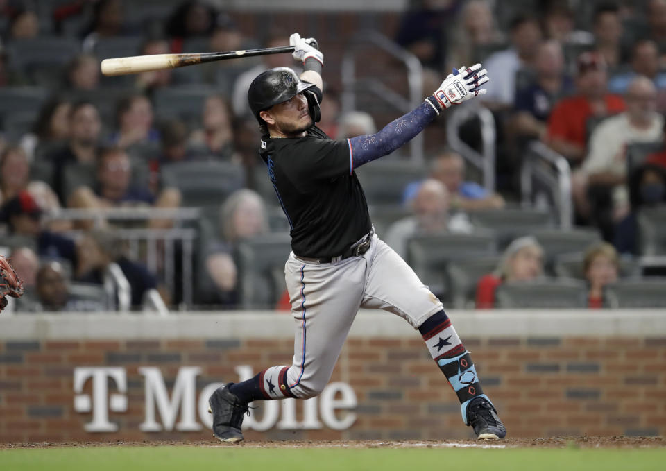 Miami Marlins' Miguel Rojas swings for a double off Atlanta Braves' Will Smith during the ninth inning of a baseball game Friday, July 2, 2021, in Atlanta. (AP Photo/Ben Margot)