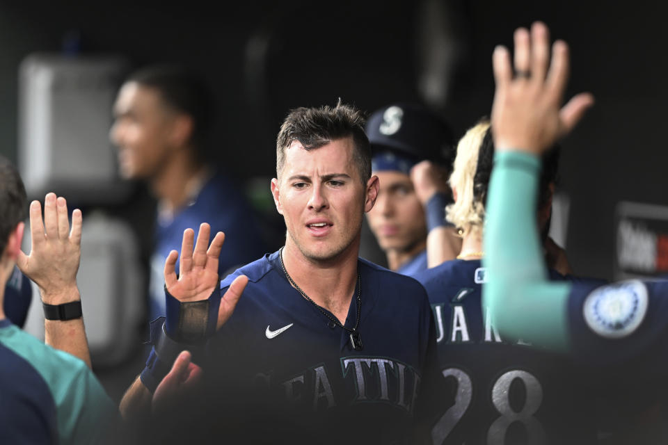 Seattle Mariners' Dylan Moore is congratulated after scoring on a single by Cal Raleigh against the Baltimore Orioles in the third inning of a baseball game Tuesday, May 31, 2022, in Baltimore. (AP Photo/Gail Burton)