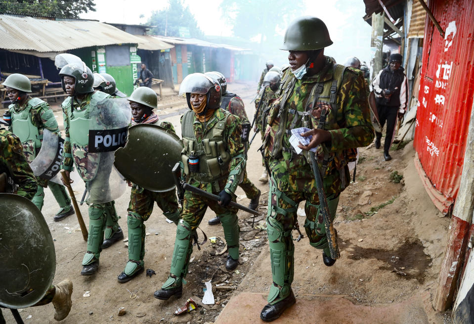 FILE - Riot policemen walk back during clashes with protesters in the Kibera area of Nairobi, Kenya on July 19, 2023. The United States is praising Kenya's interest in leading a multinational force in Haiti. But weeks ago, the U.S. openly warned Kenyan police officers against violent abuses. Now 1,000 of those police officers might head to Haiti to take on gang warfare. (AP Photo/Brian Inganga, File)