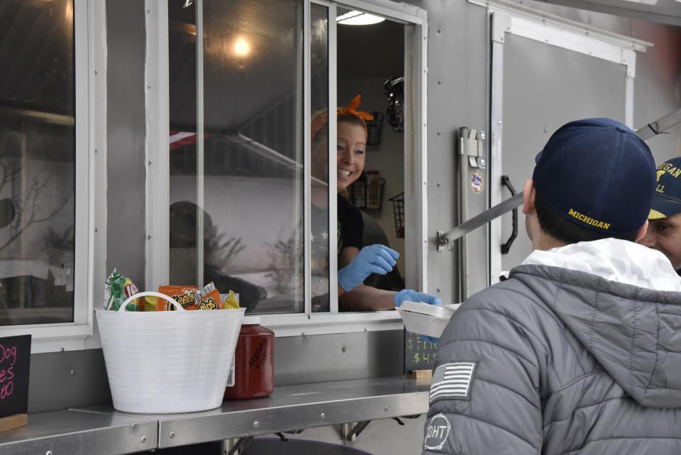 Lisa Uptgraft serves an order to Kickin Kurbz customers waiting outside The Rink in downtown Battle Creek on Friday, Jan. 14, 2022.