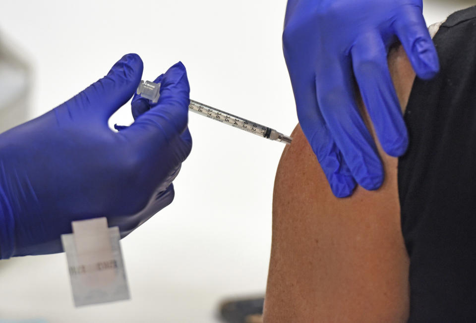 An employee of Wake Forest Baptist Medical Center, receives one of the first COVID-19 vaccines at the medical center, Tuesday, Dec. 15, 2020. Wake Forest Baptist received its first shipment of the Pfizer vaccine on Monday morning. Ten employees received the first dose of the Pfizer vaccine Tuesday. Additional employees will be given the vaccine in the coming days. (Walt Unks/The Winston-Salem Journal via AP)