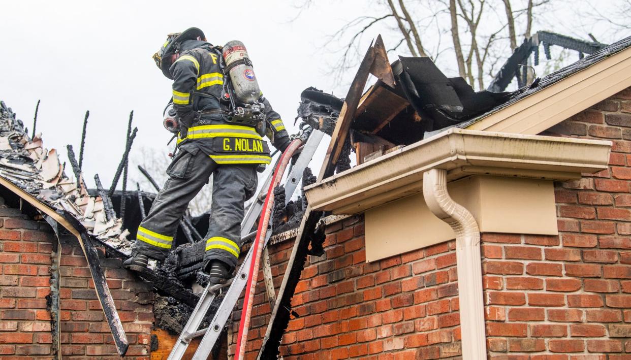 Bloomington Fire Department firefighter Garrett Nolan checks for hot spots at 2610 E. Windermere Woods Drive after a suspected lightning strike started a fire in the home on Wednesday, April 5, 2023.