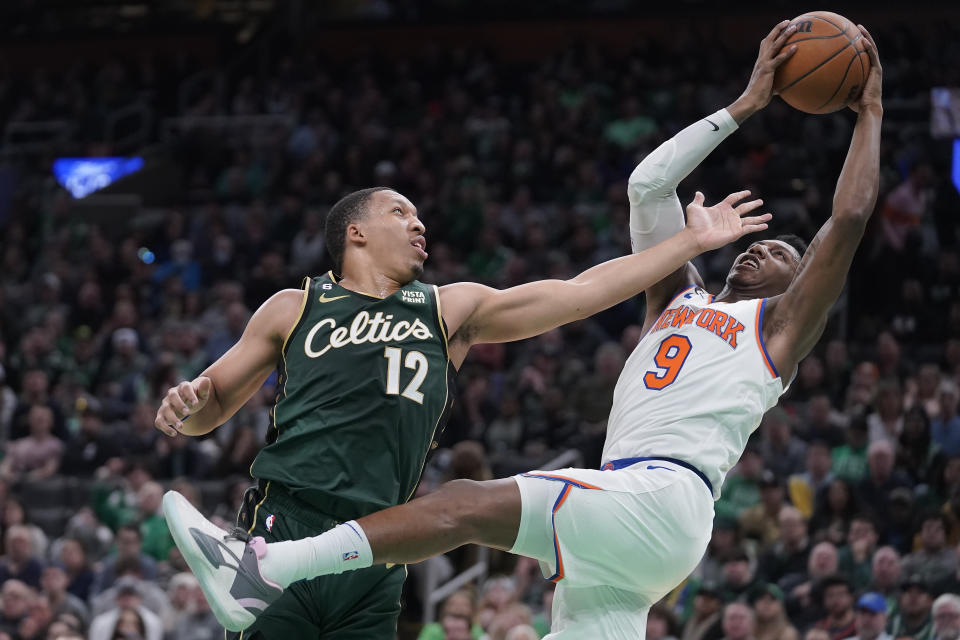 New York Knicks guard RJ Barrett (9) grabs a rebound as Boston Celtics forward Grant Williams (12) vies for the ball in the first half of an NBA basketball game, Sunday, March 5, 2023, in Boston. (AP Photo/Steven Senne)