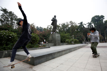 Boys ride the skateboards in front of an statue of Russian revolutionary Vladimir Lenin in a park in Hanoi, Vietnam January 23, 2019. REUTERS/Kham