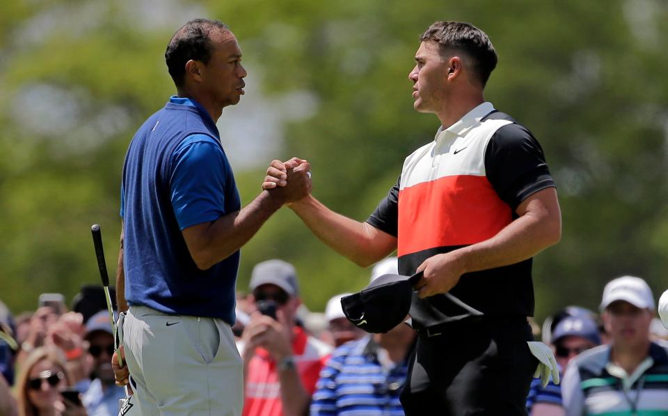 Tiger Woods, left, and Brooks Koepka shake hands after finishing the first round of the PGA Championship golf tournament, Thursday, May 16, 2019, at Bethpage Black in Farmingdale, N.Y.