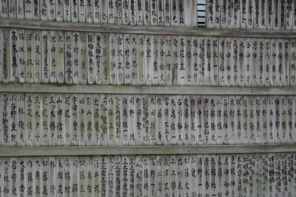 Details of Japanese characters written on wooden slats at the Okunitama Shrine during the Tokyo 2020 Olympic Summer Games at Fuji Speedway on July 24, 2021. 