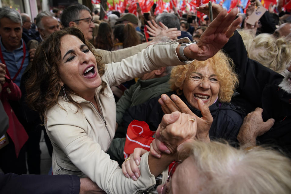 La vicepresidenta del gobierno español y ministra de Hacienda, María Jesús Montero, y otros miembros del gobierno, animan a los partidarios del presidente del gobierno español Pedro Sánchez que se reúnen en la sede del partido PSOE durante una manifestación en Madrid, España, el sábado 27 de abril de 2024. (AP Foto/Andrea Comas)