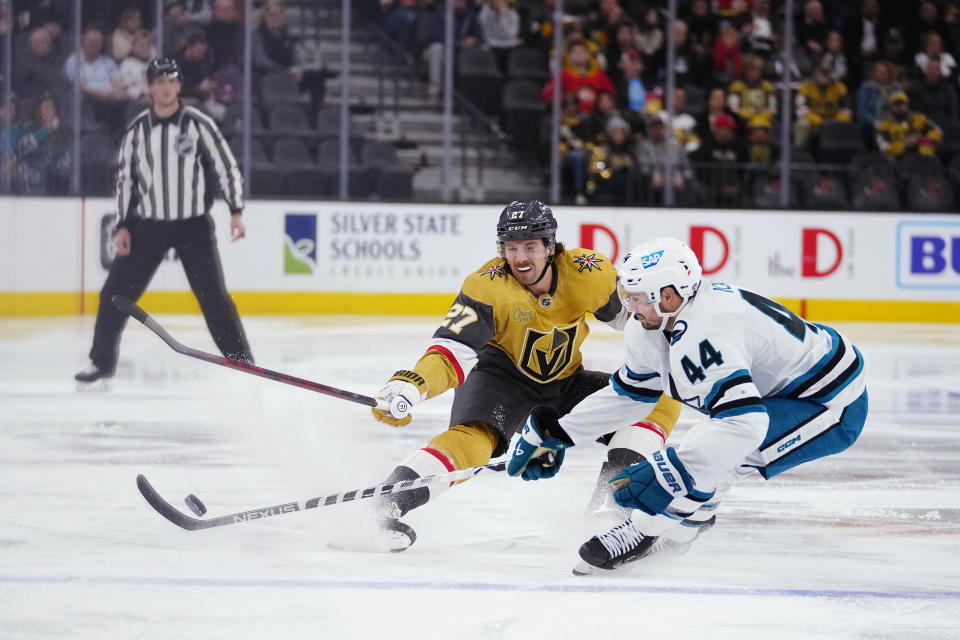 Vegas Golden Knights defenseman Shea Theodore (27) defends against San Jose Sharks defenseman Marc-Edouard Vlasic (44) during the second period of an NHL hockey game Tuesday, Nov. 15, 2022, in Las Vegas. (AP Photo/Eric Jamison)