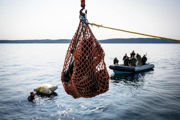 Joint Task Force Atlantic crew members retrieve unexploded ordnance near Bell Island on July 15. (Joint Task Force Atlantic/Twitter - image credit)