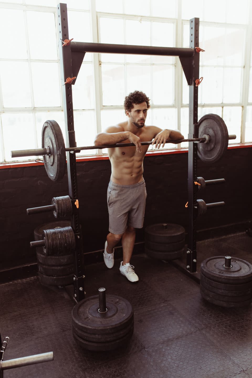 man leaning over barbell after workout