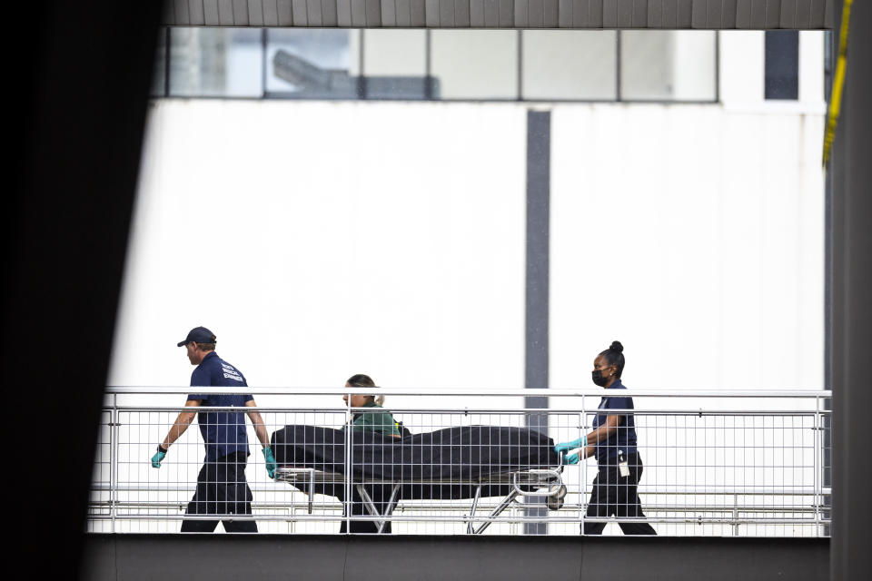 Medical examiners remove a body from the third floor of 1201 San Jacinto following a shooting, Tuesday, Nov. 1, 2022. The rapper Takeoff, best known for his work with the Grammy-nominated trio Migos, died after a shooting early Tuesday outside of 810 Billiards & Bowling in Houston, a representative confirmed. He was 28. (Annie Mulligan/Houston Chronicle via AP)