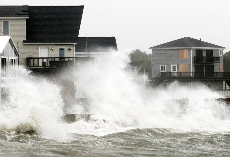 FILE - Waves crash along a seawall as Tropical Storm Irene, downgraded from a hurricane, slammed into Fairhaven, Mass., Aug. 28, 2011. New England is known for its fickle weather, powerful nor'easters and blizzards. Destructive hurricanes, however, are relatively rare and typically don't pack the same punch as tropical cyclones that hit the Southeast. Hurricanes usually lose some steam, becoming tropical storms, or extratropical storms, in northern waters. (AP Photo/Winslow Townson, File)