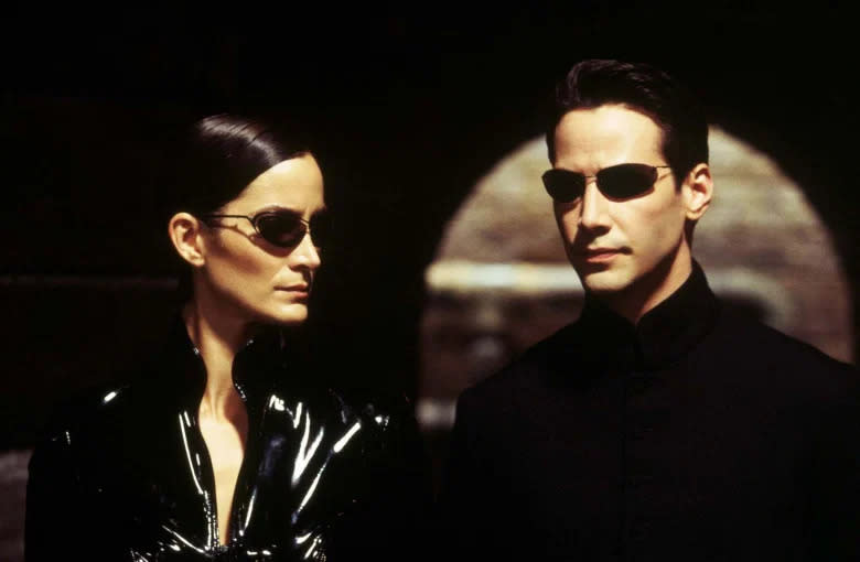 Carrie Ann-Moss and Reeves in The Matrix (Credit: Warner Bros)