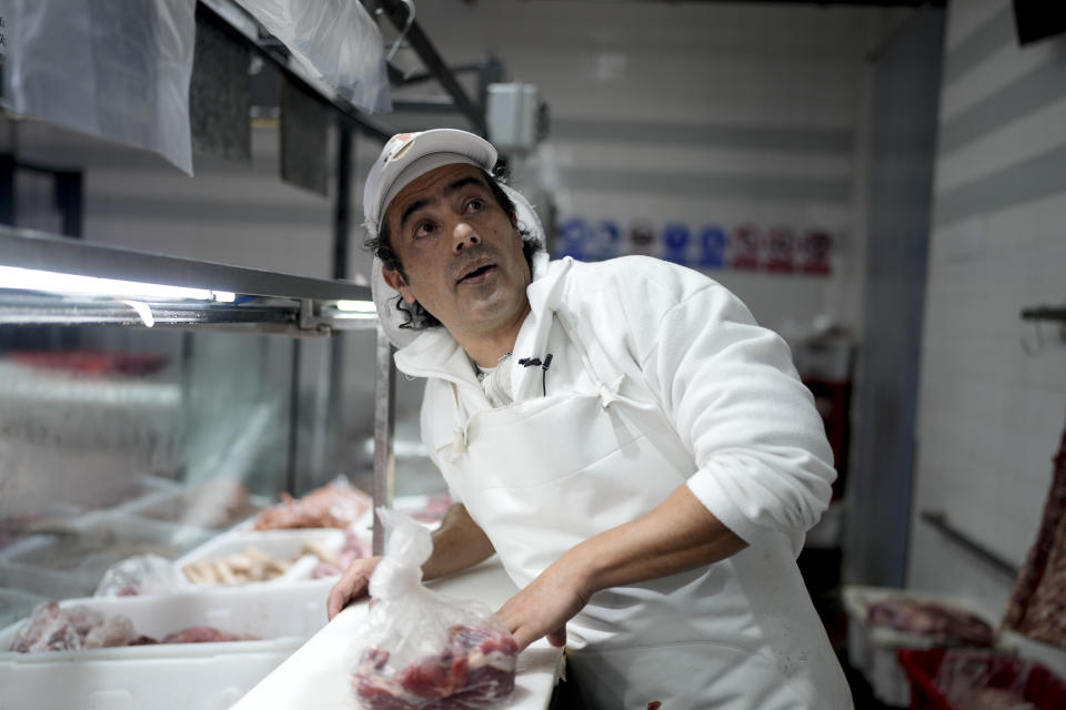 El carnicero Mario Giménez corta carne en la carnicería donde trabaja en Buenos Aires, Argentina, el viernes 18 de agosto de 2023. Giménez dijo que ya no cree en las promesas de justicia social del peronismo y votó en las primarias por el candidato de derecha Javier Milei. (AP Foto/Natacha Pisarenko)