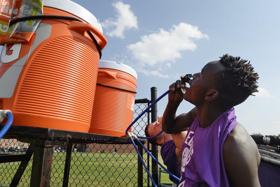 Staying hydrated is part of staying safe during summer workouts. <a href="https://www.gettyimages.com/detail/news-photo/james-opio-and-lucas-harbaugh-in-background-drink-some-news-photo/1025049102" rel="nofollow noopener" target="_blank" data-ylk="slk:Shawn Patrick Ouellette/Portland Portland Press Herald via Getty Images;elm:context_link;itc:0;sec:content-canvas" class="link ">Shawn Patrick Ouellette/Portland Portland Press Herald via Getty Images</a>