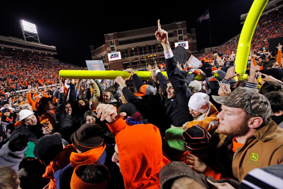 OSU fans celebrate with a goal post they tore down after a 44-10 win against OU in Stillwater on Dec. 3, 2011.